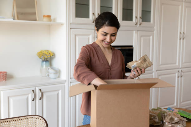 puas wanita muda india membongkar kotak dengan bahan makanan yang dipesan secara online - home delivery potret stok, foto, & gambar bebas royalti