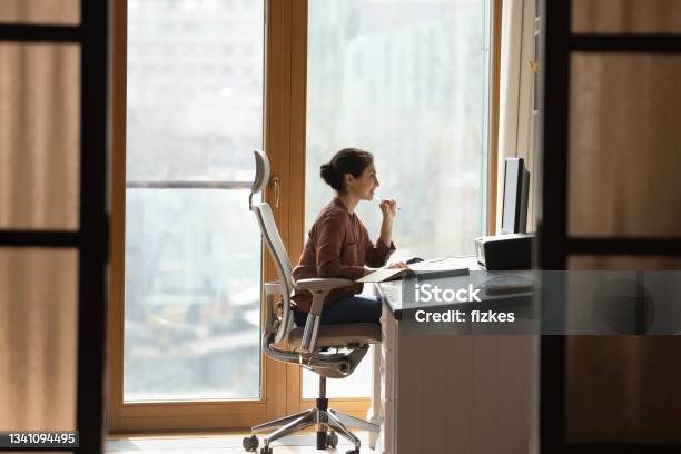 Indian Female Sit At Workplace On Ergonomic Chair Use Pc Stock Photo - Download Image Now