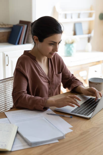 istock Millennial indian female work on laptop computer at home office 1341094511