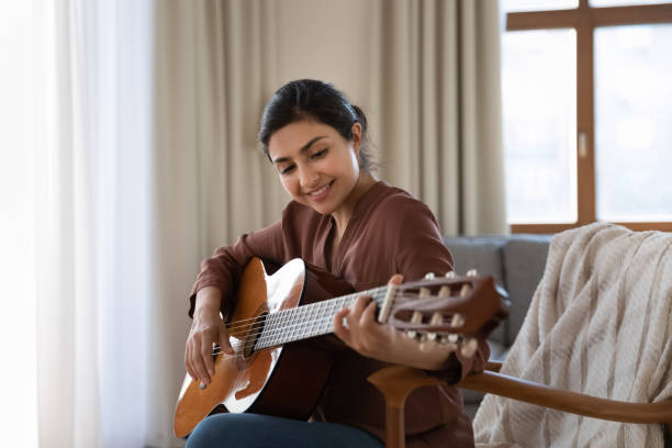 talented young biracial female musician composing instrumental song using guitar - hobbies imagens e fotografias de stock