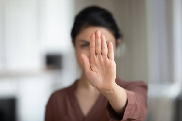 istock Courageous young female extend hand in stop gesture saying no 1341094534