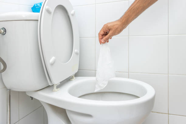 istock Hand throwing wet wipe into toilet 1341095455