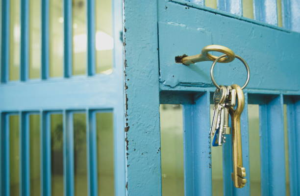 la porte de la prison avec les clés dans la serrure - prison cell photos et images de collection