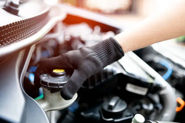 Photo of Hand of Technician checking brake fluid  in engine room maintenance and basic service concept of the car and brake system