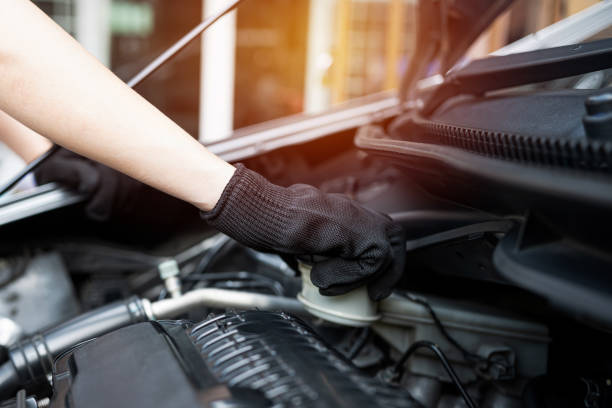 istock Hand of Technician checking brake fluid  in engine room maintenance and basic service concept of the car and brake system 1341095620