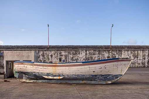 Old wooden boat on a pier in Ponta Delgada which is the main city on the Portuguese Azorean island San Miguel in the center of the North Atlantic Ocean
