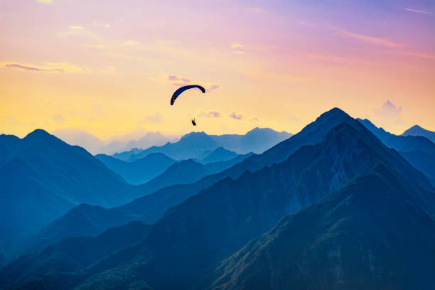 volo da sogno al tramonto in montagna - skydiving parachuting extreme sports airplane foto e immagini stock