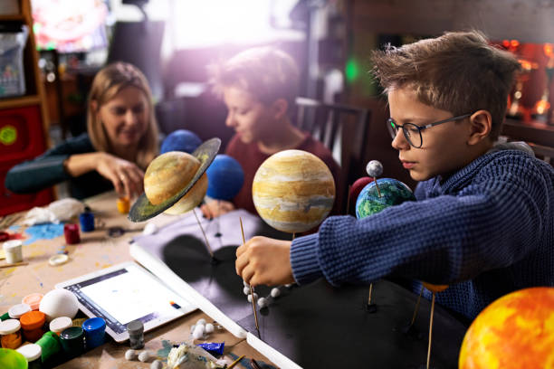 mother helping sons to create a solar system model at home - earth globe mother child imagens e fotografias de stock