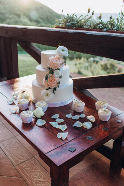 istock White wedding cake with flowers on a wooden table. 1341104221