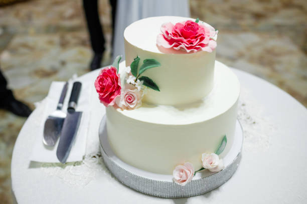 istock White wedding cake with flowers on a wooden table. 1341104384