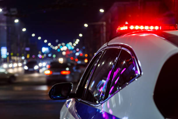 police car lights in night city with selective focus and bokeh police car lights at night in city with selective focus and blurry car traffic in the bokeh police lights stock pictures, royalty-free photos & images