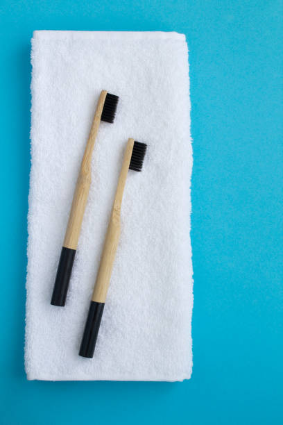 istock Bamboo toothbrushes and white  towel on the blue background. Top view. Copy space. 1341104877