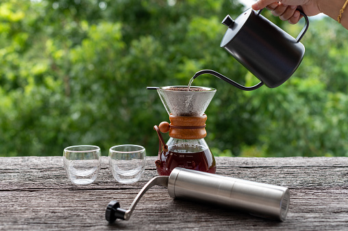 Drip coffee with equipments on wooden table, outdoor