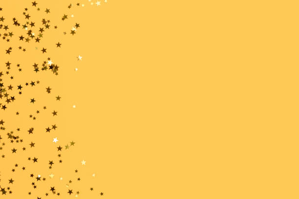 istock Glowing gold colored stars confetti with copy space. 1341108738