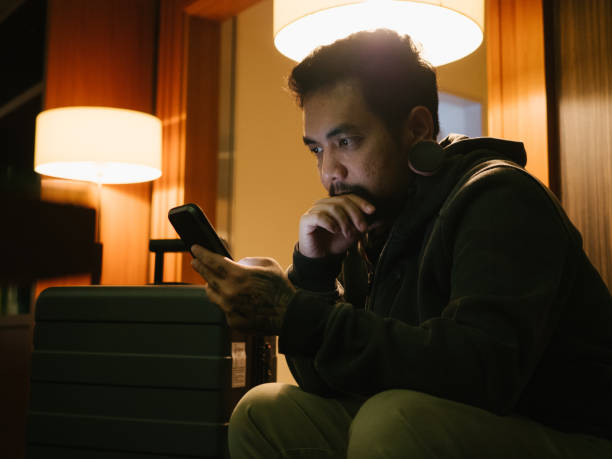 istock Businessman using mobile phone in a hotel lobby. 1341112275