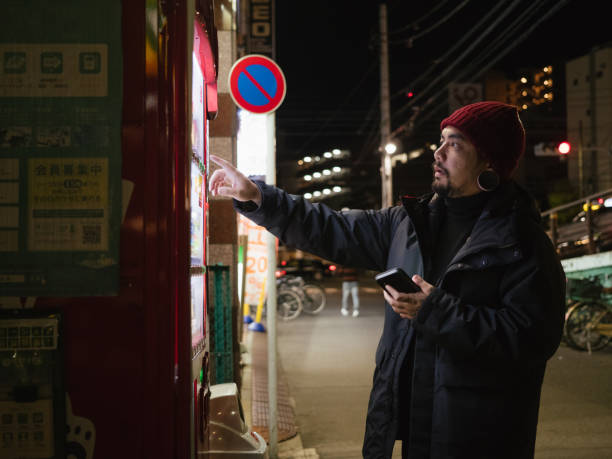 istock Hipster man paying with smartphone to vending machine. 1341113337