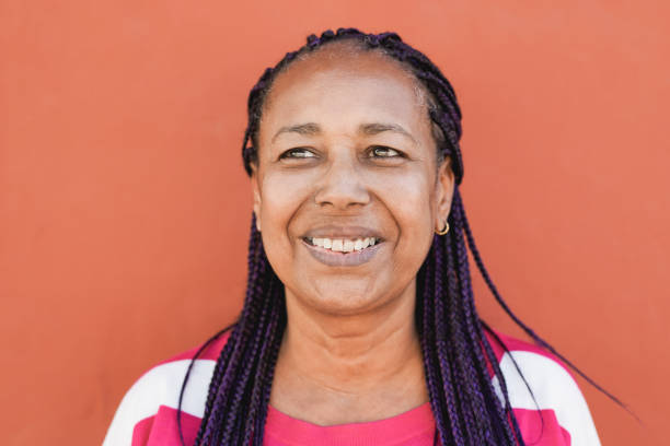 istock African senior woman smiling with red background 1341113369