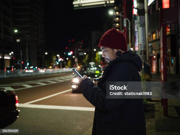 Young Asian Man Waiting For Taxi Or Uber In Tokyo City At Night Stock Photo - Download Image Now