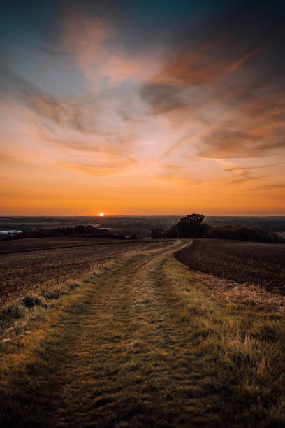 Very red orange autumn sunset across a farmers field in england.