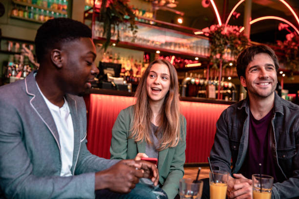 istock Happy group of friends celebrating in a pub 1341120620