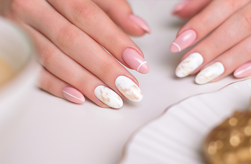 Beautiful female hands with luxury manicure nails, pink and white gel polish