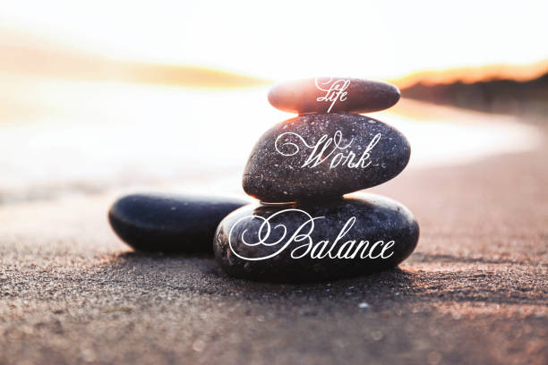 istock Work-life balance concept. Stacked stones on sandy beach at sunset 1341126644