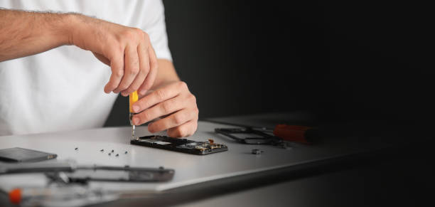 istock Technician repairing mobile phone at table, space for text. Banner design 1341126707