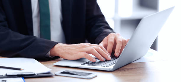 istock Man working on computer at table in office, closeup. Banner design 1341127034