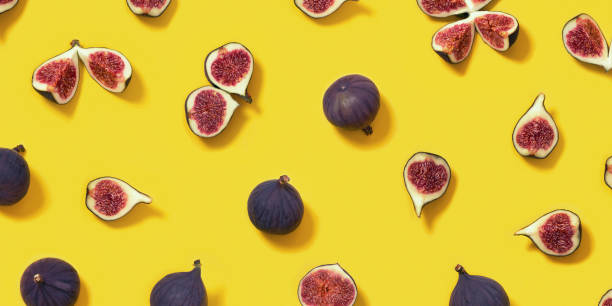 istock Colorful fresh figs fruit pattern on bright yellow background, whole and sliced fig. 1341129629