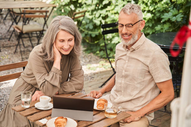 istock Mature wife and husband spending weekend with tablet while sitting at the cafe 1341129806