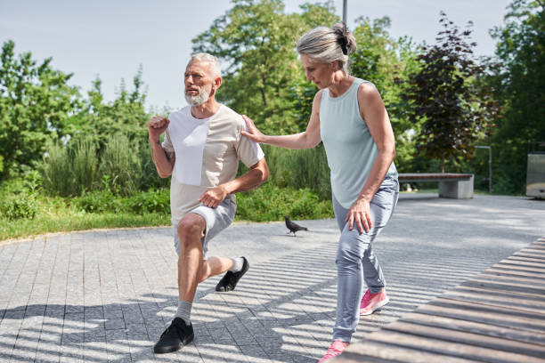istock Senior married couple making lunges while training at the morning at the fresh air 1341129863