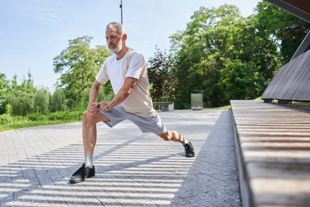 istock Elderly man making lunges while training at the summer park at the fresh air 1341129886