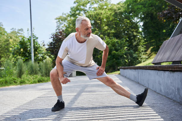 istock Mature man stretching body and feeling flexible while exercising at the park 1341129887