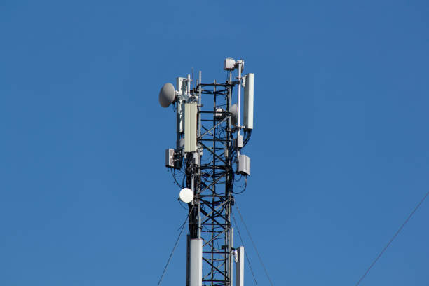 istock Mobile cell phone tower against the background of a blue sky and white cloud. Telecommunication TV tower. Cellular antenna. Wi-fi transmitter and receiver module 1341133573
