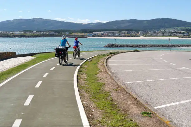 Photo of Cyclists riding on a bike path with the sea in the background