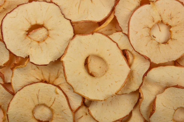 Close up many dried crispy apple ring chips on retail display, elevated top view, directly above
