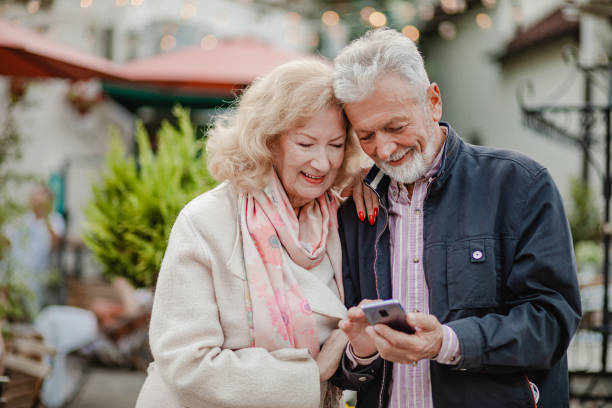 istock Lovely senior couple using mobile phone on the street 1341136953