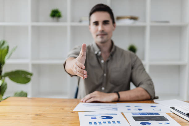 istock handsome man extends their hands as if asking for a handshake, a business man extends her hand forward to shake a business partner, a handshake to congratulate or pay respects after a business talk. 1341139890