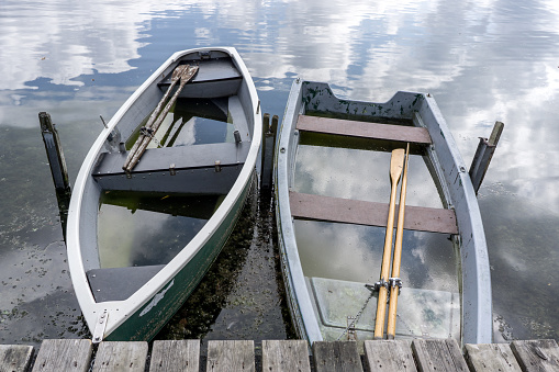 two small wrecked row boats full of water on a lake