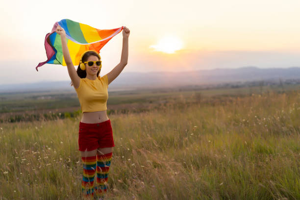 istock Young girl holding a rainbow flag at sunset 1341144118