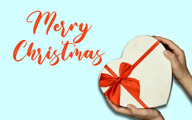 istock hands holding closed heart shaped box  with merry Christmas text on blue background 1341145609