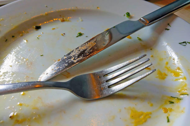 istock Fork and knife on a white plate after eating. 1341145625