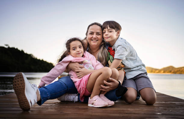 Mother and children smiling outdoors. Happy family concept. stock photo