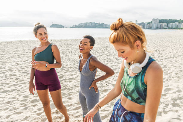 istock Three attractive women in sportswear exercise on the beach 1341148147