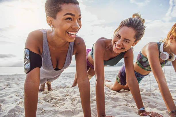 istock Three young women doing push-ups on the beach 1341149354
