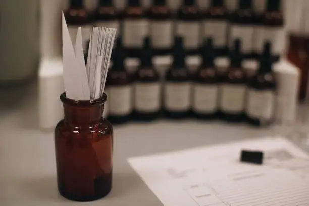 Photo of Mockup brown glass bottle with blotter paper for testing smell of essential oil and fragrance oil.