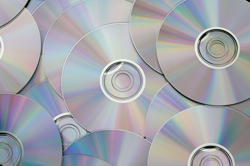 Damaged CD, DVD compact disc. Data destruction. Broken CD and DVD disc isolated on black background, space for text