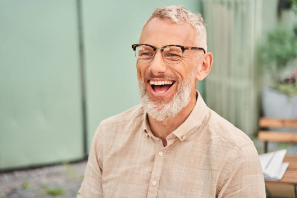 Man laughing out loud while chatting with his wife during the romantic date stock photo