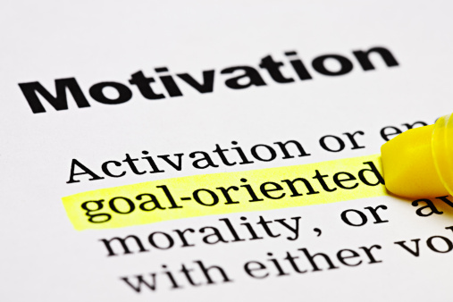 A yellow marker highlights the word 'goal-oriented' under the heading 'Motivation' in a printed document. Shot with Canon EOS 1Ds Mark III. 