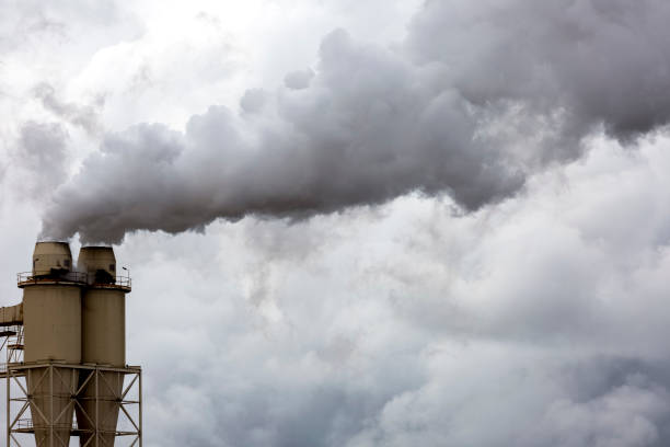 istock Clouds of dark smoke from industrial chimneys, background with copy space 1341159600
